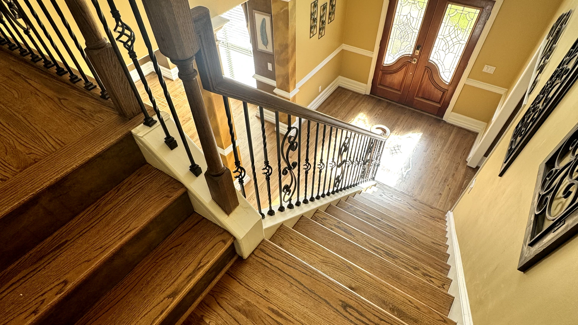 Wood staircase with dark metal balusters and matching handrail