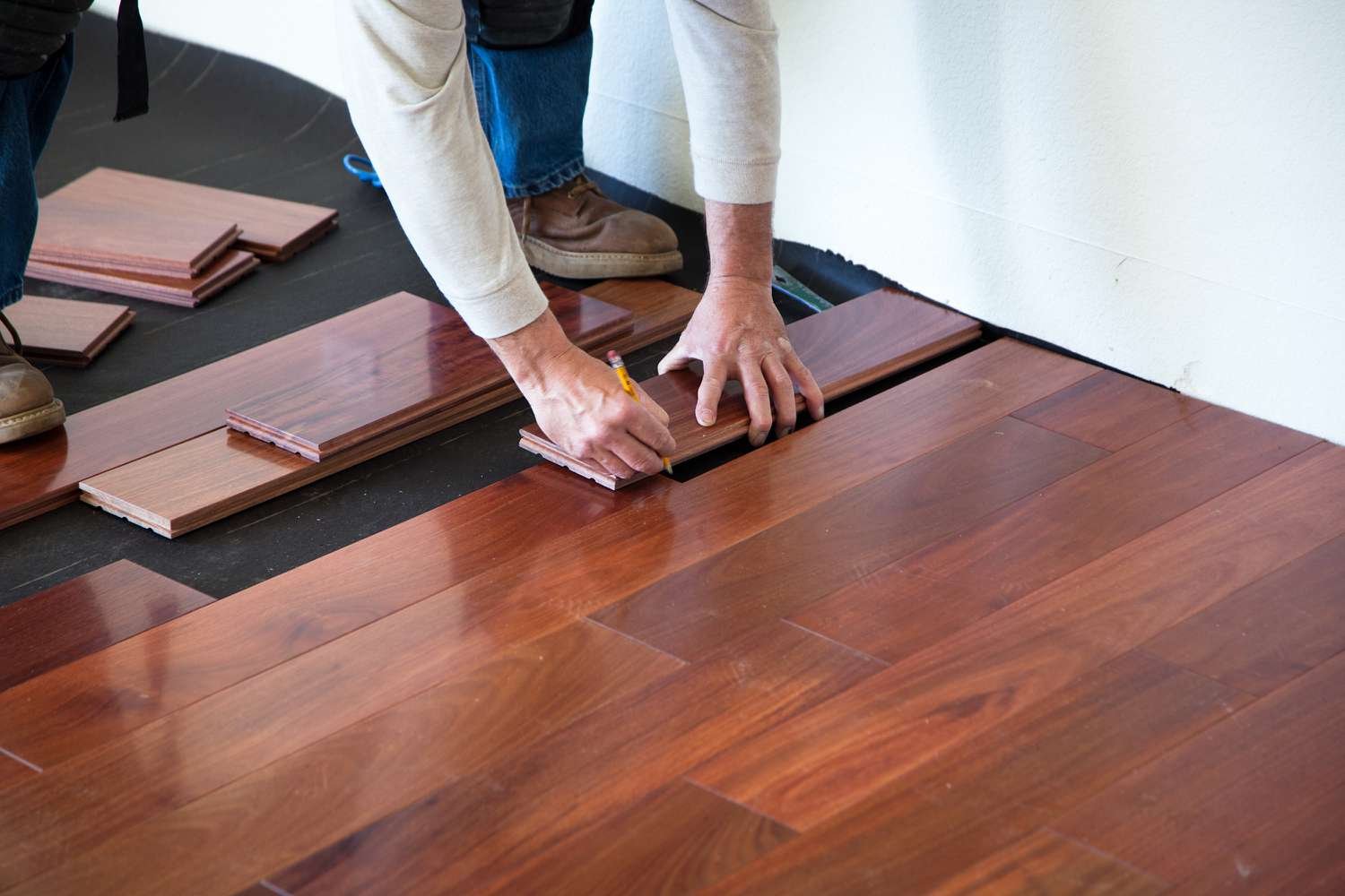Installer setting a wood plank during floor installation